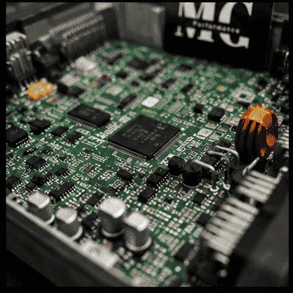 Nahaufnahme einer Steuergeräte-Platine mit Mikrocontroller, Kondensatoren und Endstufen